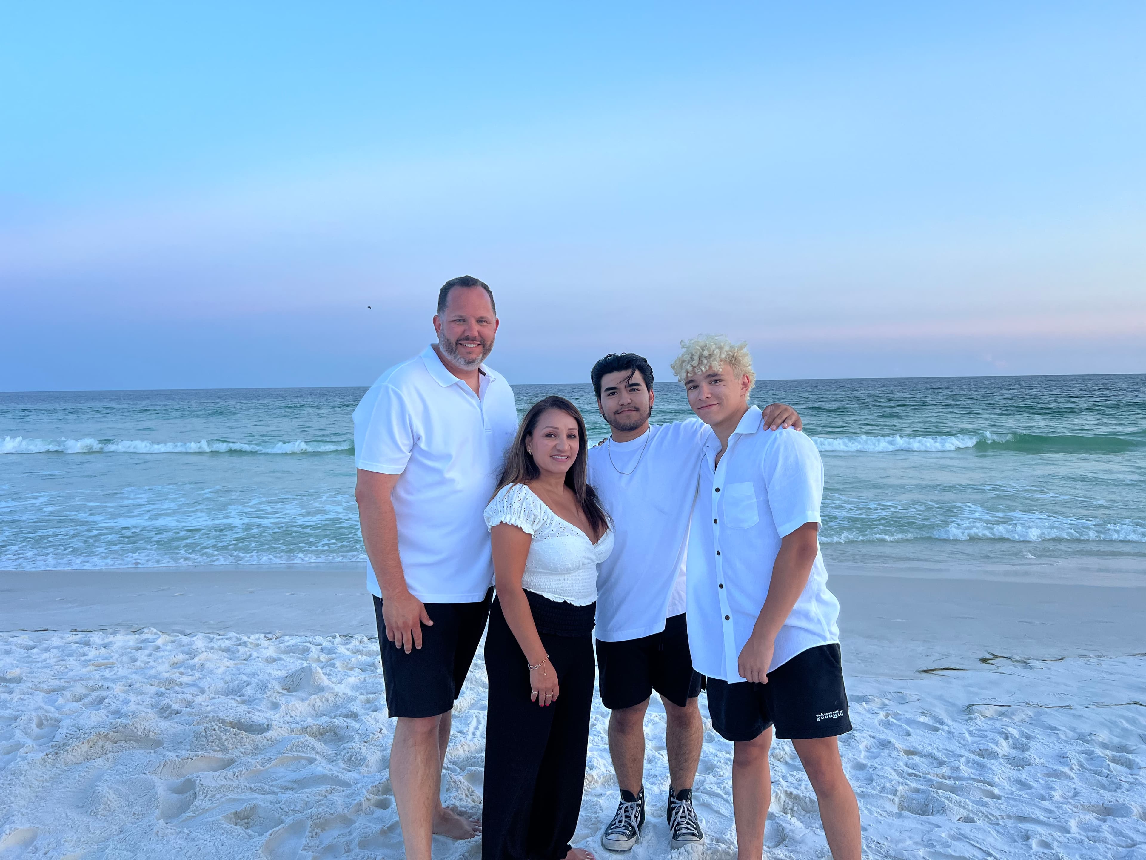 Jason with his wife Maria and their two sons, Tony and Kaleb, on the beach in Destin at sunset